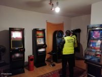 Funkcjonariusz służby celno - skarbowej i policjant w pomieszczeniu z maszynami do gier hazardowych