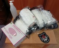 maseczki, rękawiczki jednorazowe, płyn do dezynfekcji oraz emblemat z napisem Policja Wydział Prewencji