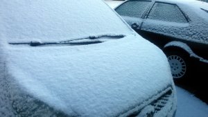 Samochody przykryte śniegiem.