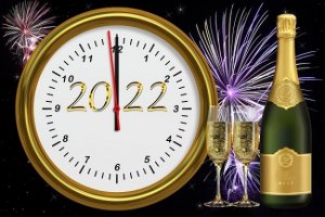zegar z datą 2022 szampan, dwa kieliszki i fajerwerki w tle