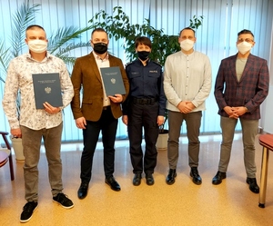 Czterech policjantów w ubiorze cywilnym z czego dwóch odchodzący na emeryturę z podziękowaniami w ręce,  oraz Komendant Powiatowy Policji w Rawie Mazowieckiej w mundurze insp. Anna Dyśko.