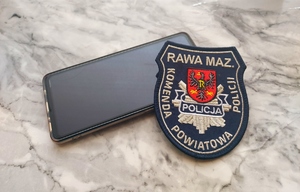 Telefon i naszywka policyjna napis komenda powiatowa policji.