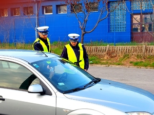 policjanci badają trzeźwość kierowcy, na zdjęciu policjanci w mundurach i auto