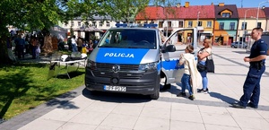 radiowóz policyjny, policjant dziecko i kobieta.