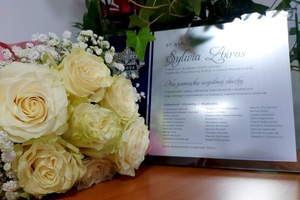 Bukiet kwiatków oraz tabliczka pamiątkowa z napisem Sylwia Zbiros na pamiątkę wspólnej służby.