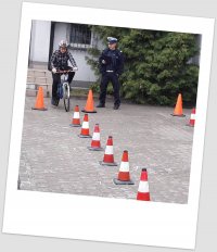 chłopiec na rowerze, pachołki i policjant