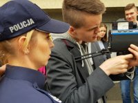 policjantka i uczniowie korzystający z miernika prędkości