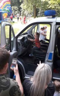 dziecko za kierownicą w radiowozie i inni uczestnicy festynu