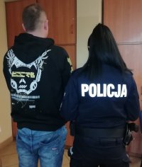 Umundurowana policjantka z jednym z zatrzymanych mężczyzn.