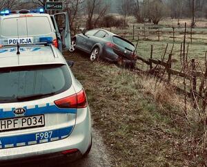 Radiowozy policyjne i samochód w rowie osobowy.