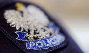 Biały orzeł w złotej koronie pod spodem napis policja.