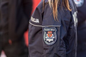 Rękaw policjantki z naszywką z napisem Rawa Mazowiecka Komenda Powiatowa Policji, opadające włosy na ramię.