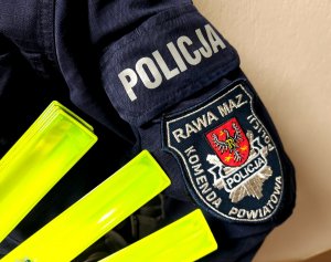 Rękaw munduru na którym jest emblemant komendy powiatowej policji w rawie mazowieckiej oraz elementy odblaskowe.