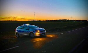 Radiowóz policyjny stojący przy drodze.