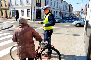 Policjant wręcza odblask rowerzystce.