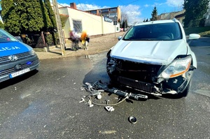 Rozbity samochód stojący na skrzyżowaniu oraz radiowóz.