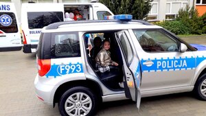 Dziecko siedzące w radiowozie.