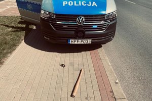 Radiowóz policyjny pałka drewniana i kastet leżący na chodniku.