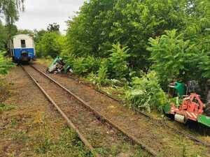 Tory, wagon kolejki wąskotorowej, ciągnik rolniczy w dwóch osobnych częściach.
