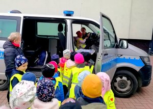 Dzieci w kamizelkach i radiowóz.