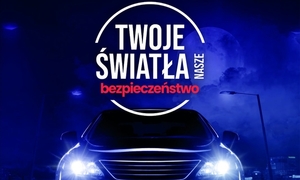 auto z włączonymi światłami i napis twoje światła nasze bezpieczeństwo