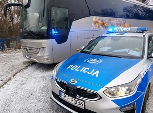 Radiowóz policyjny i autobus na zajezdni.