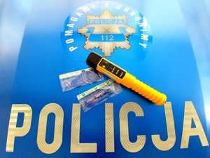 maska radiowozu z napisem policja na niej urządzenie do badania trzeźwości oraz odblaski.