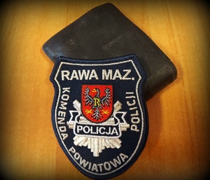 portfel a na nim nalepka komendy powiatowej policji w Rawie Mazowieckiej z herbem.