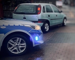 samochód i radiowóz na podjeździe.