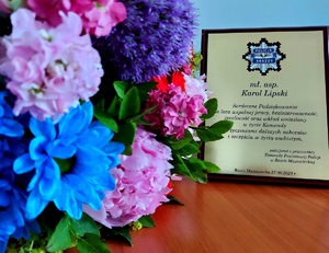 Tabliczka pamiątkowa z podziękowaniami za służbę oraz bukiet kwiatów.