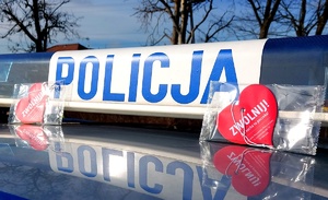 Napis policja na belce radiowozu i dwa serduszka zapachowe.