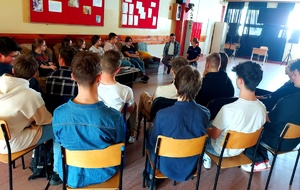Policjant i policjantka siedzący razem z młodzieżą.