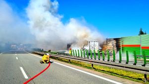 Paląca się naczepa, strażacy gaszący pożar.