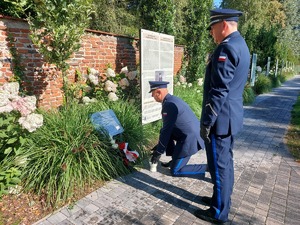 Policjant stawia znicz, Komendant stoi.