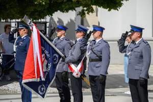 Policjanci salutują, pochylony sztandar.