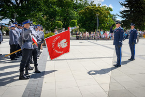 Komendant Wojewódzki wita się ze sztandarem, policjanci salutują.