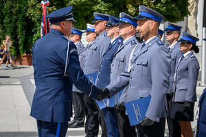 Komendant wręcza akt mianowania policjantowi.