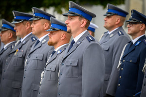 Policjanci stojący obok siedzie.