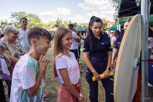 Policjantka przy kole fortuny z dziećmi.