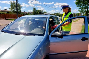 Policjantka wręczająca apteczkę kierowcy.