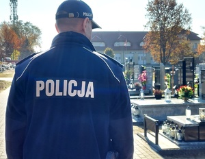 Policjant idący przez cmentarz.