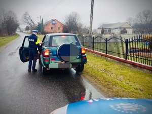 Policjant, samochód i maska radiowozu.