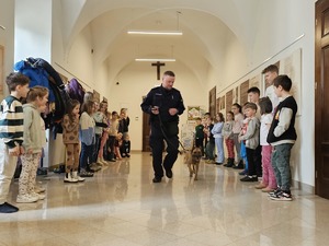 Policjant z psem obok dzieci.