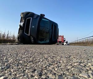 Bus leżący na boku dalej straż pożarna.