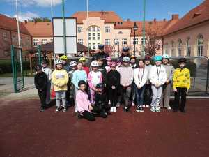 Policjanci stojący za dziećmi podczas zdjęcia grupowego.