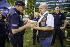 Komendant wręcza podarunek motocykliście.