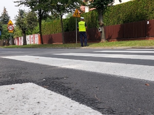 Policjant przy znaku drogowym i przejcie dla pieszych.