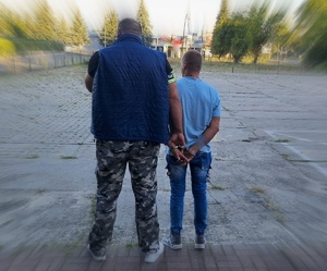 Policjant w cywilnym umundurowaniu i zatrzymany mężczyzna.