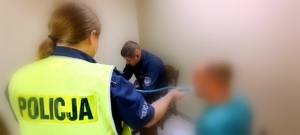 Policjanci i mężczyzna podczas badania alkomatem.