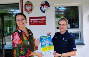 Policjantka z dyrektorka trzymają plakat.